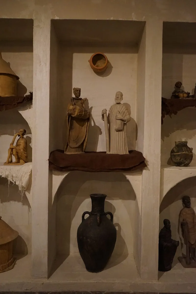 Sculpted museum niches holding figures and artifacts in a heritage room