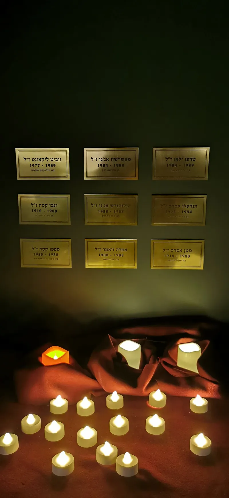Memorial candles glowing in a hand-built niche in a Shidrah Studio memorial room
