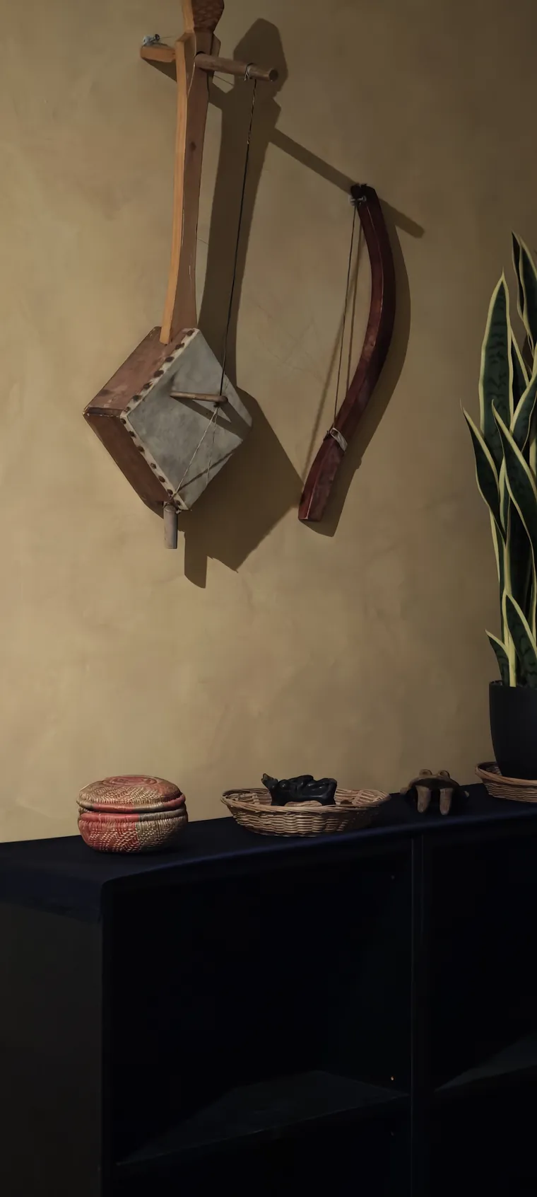 Traditional Ethiopian string instruments mounted on a hand-finished ochre wall