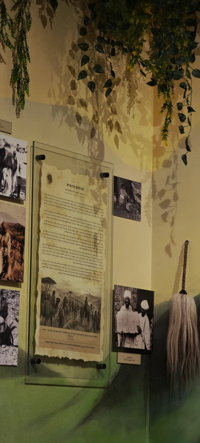 Scroll-form panel with a traditional broom and archival photographs