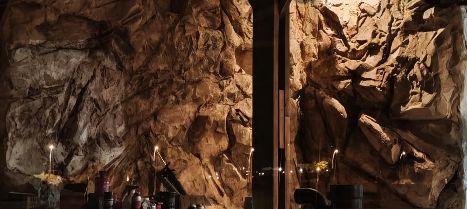 Carved stone feature wall lit by candlelight in the Negev luxury restaurant by Shidrah Studio